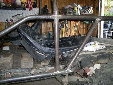 1979 Ford Bronco - Interior view of a vehicle undergoing modification with a custom roll cage and seats.