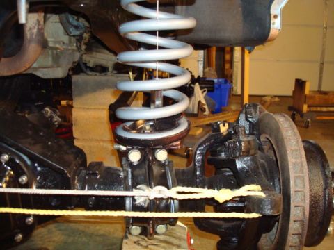 1995 Ford Bronco - Detailed view of a vehicle's axle and suspension system, showing mechanical components and a coil spring.