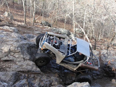 1967 Ford Mustang - Custom buggy with exposed engine and roll cage climbs over large rocks on a trail.
