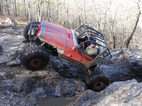 1967 Ford Mustang - A driver maneuvers a heavily modified off-road vehicle through a challenging rocky landscape.