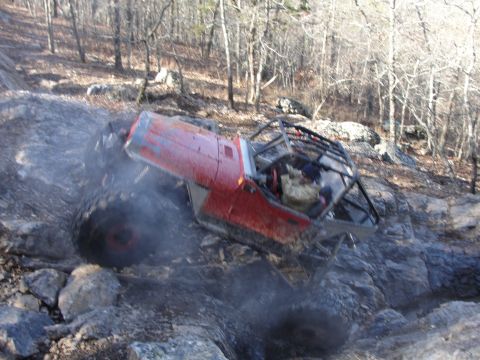 1967 Ford Mustang - An off-road vehicle navigates a challenging rocky trail, kicking up dust and debris.