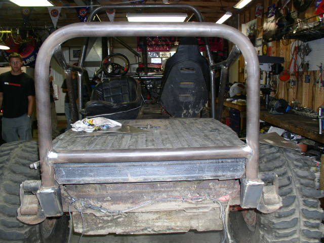 Rear view of a custom off-road vehicle with a roll cage and large tires