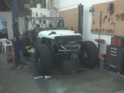 1994 Jeep YJ - This modified 1994 Jeep YJ is undergoing work in a garage, elevated on a lift.