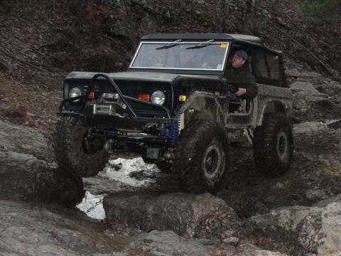 1967 Ford Mustang - A driver maneuvers a modified off-road vehicle through a challenging rocky path.