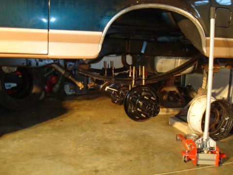 1995 Ford Bronco - Underneath view of a vehicle's rear axle and suspension system during maintenance.