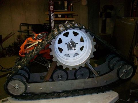 1987 Suzuki Samurai - A custom track system, possibly for a snowmobile, is shown with a large white wheel and gear mechanism.