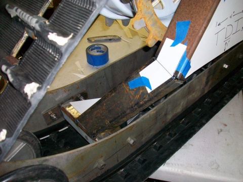 1987 Suzuki Samurai - Close-up view of a snowmobile track assembly, showing modifications with blue tape and paper templates.