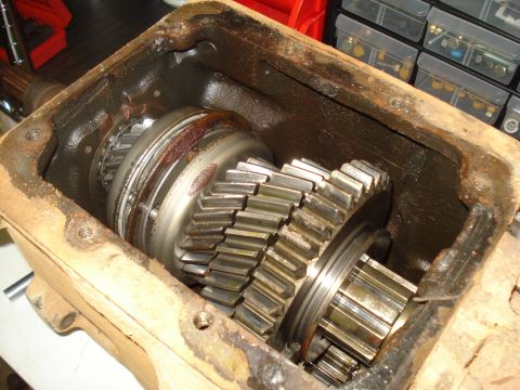 1991 Ford Bronco - Close-up view of the internal gears within a transmission housing, showing signs of wear and rust.