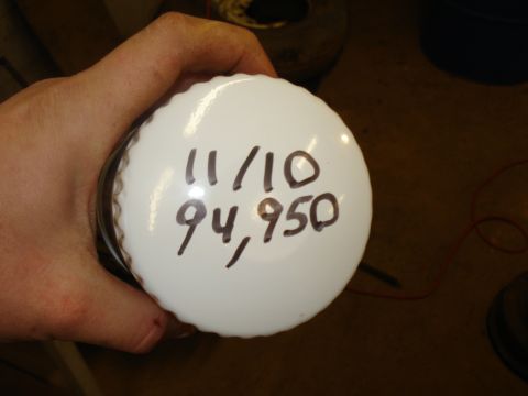 1985 Ford F-150 - A hand holds an oil filter marked with a date and mileage, likely indicating service records.