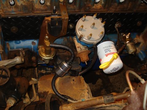 1985 Ford F-150 - Close-up view of engine components including a distributor cap and a white oil filter with yellow pull strap.