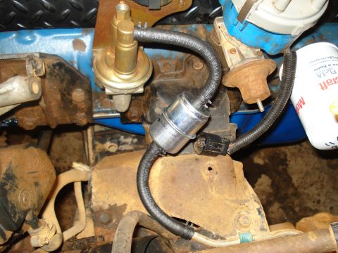1985 Ford F-150 - Close-up view of an engine's fuel filter and fuel pump, showing various hoses and components.