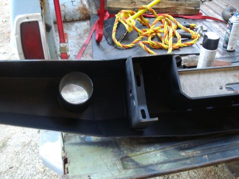 1985 Ford F-150 - A black aftermarket bumper with a circular cutout is shown, with various tools and supplies in the background.