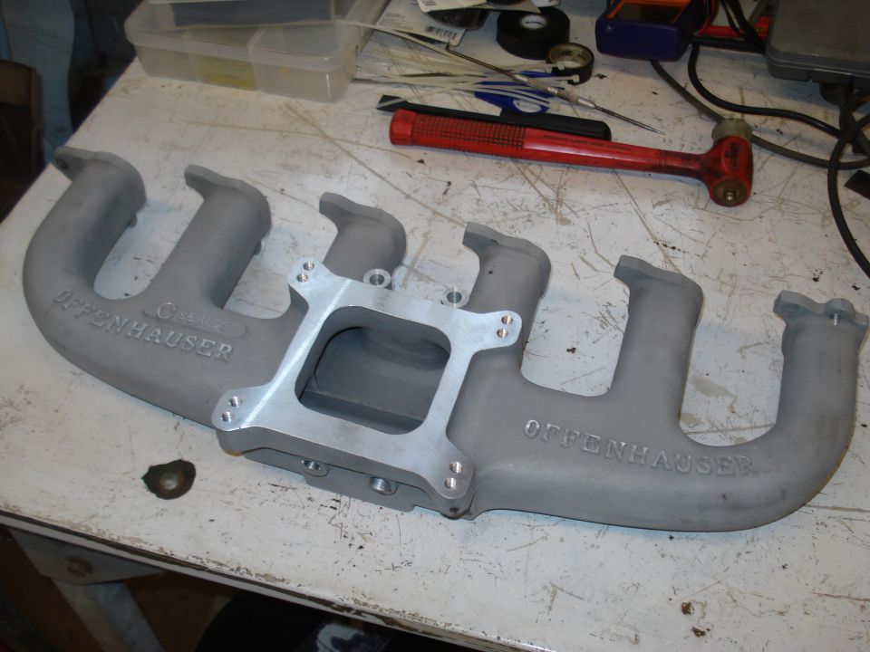 Offenhauser intake manifold on a workbench with tools in the background