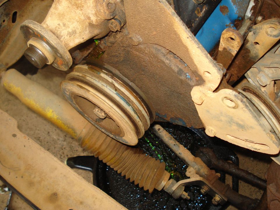 Close-up of a dirty engine pulley and a ribbed steering component