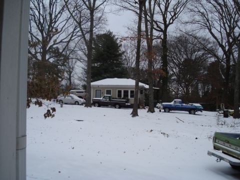 1994 Ford F-350 - Several vehicles are parked in a yard covered in snow, with a small building in the background.