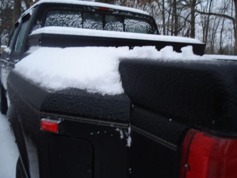 1994 Ford F-350 - A black 1994 Ford F-350 pickup truck is seen from the rear, partially covered in snow during winter.
