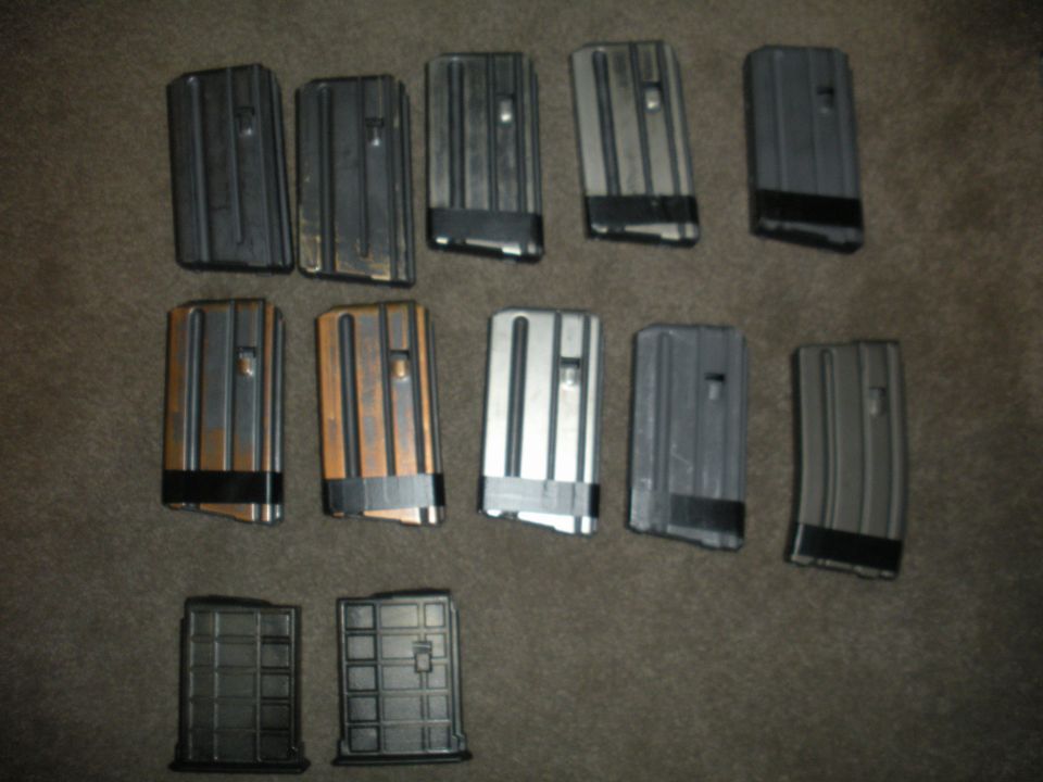 Several firearm magazines laid out on a carpeted surface