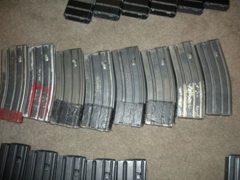 1996 Ford Bronco - A collection of rifle magazines is laid out on a carpeted floor, possibly indoor, surface.