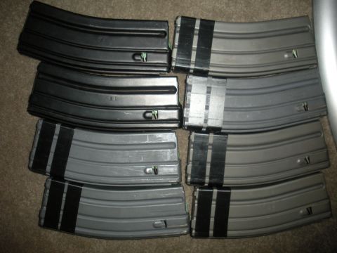 1996 Ford Bronco - A collection of firearm magazines, some black and some gray, are arranged in stacks on a carpeted surface.