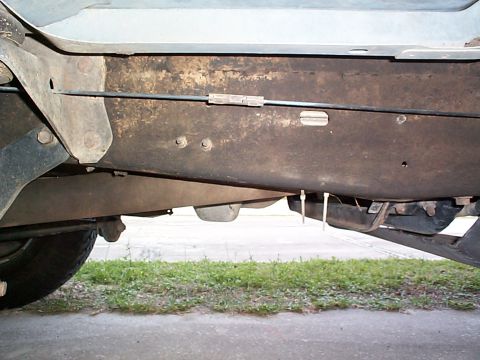 1992 Ford Bronco - This is where the emergency brake cable runs along the drivers side frame rail. The slider will mount behind this. The bolts holding the fu…
