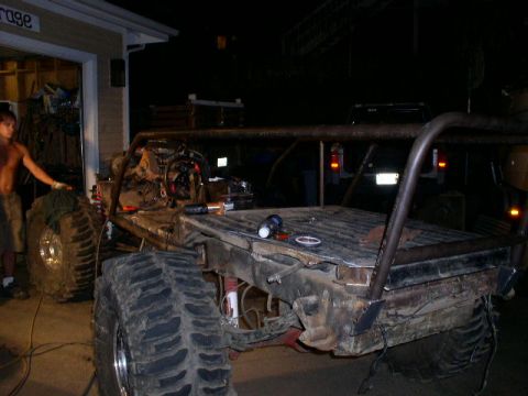 1979 Ford Bronco - A custom-built buggy with oversized tires and a roll cage is shown in a garage setting at night.