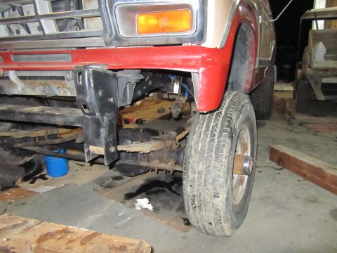1984 Ford Bronco - Close-up of a Ford Bronco's front suspension and fender area, with visible leaf springs.