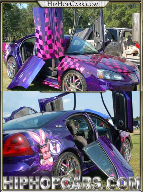 1972 Ford Ranchero - This heavily customized purple sedan features butterfly doors and unique checkered graphics on the hood and doors, along with a custom bunn…