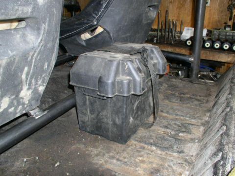 1979 Ford Bronco - A battery box is visible inside a vehicle, next to a seat and roll cage components.