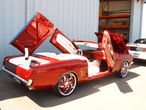 1956 Ford Fairlane - This custom convertible features gullwing doors and a white interior, with another vehicle visible in the background.