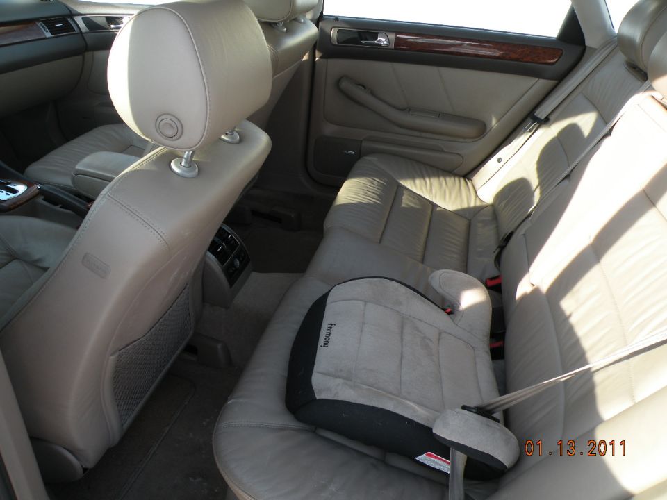 2000 Audi A6 interior showing leather rear seats and a child booster seat on the right