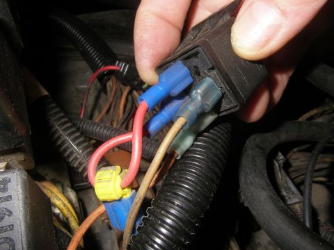 1990 Ford Bronco - A hand holds a black relay marked 'Made in Germany' with its wiring exposed, showing blue and clear crimp spade terminals pushed onto the r…