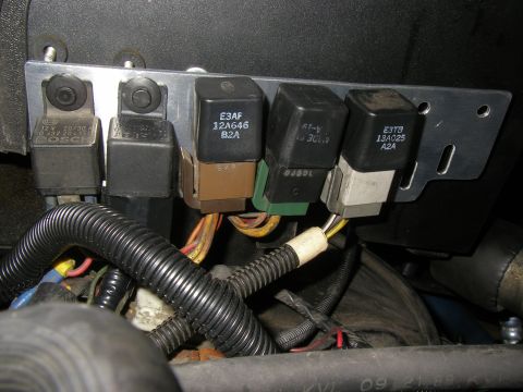 1990 Ford Bronco - Underhood bracket holding five automotive relays, including Bosch and Ford units marked E3AF 12A646 and E3TB 13A025, above wiring.
