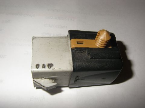 1990 Ford Bronco - Close-up of an electrical relay connector, black and tan plastic components and the marking '0 A D'.