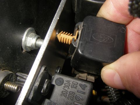 1990 Ford Bronco - Close-up of a hand disconnecting a Ford relay, showing part numbers.