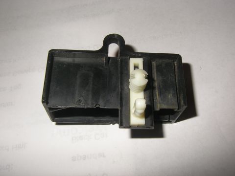 1990 Ford Bronco - This is a close-up view of a black plastic electrical relay housing with white plastic clips.