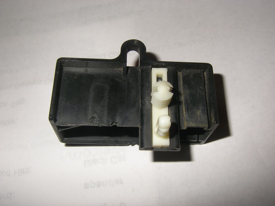 Black plastic electrical relay housing with white plastic clips inside