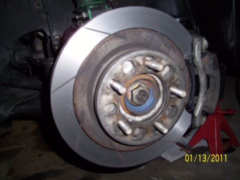 1995 Ford Probe - Close-up of a car's brake system, showing the rotor, caliper, and hub assembly.