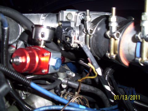 1995 Ford Probe - Close-up view of engine components, including a red fuel pressure regulator and associated plumbing.