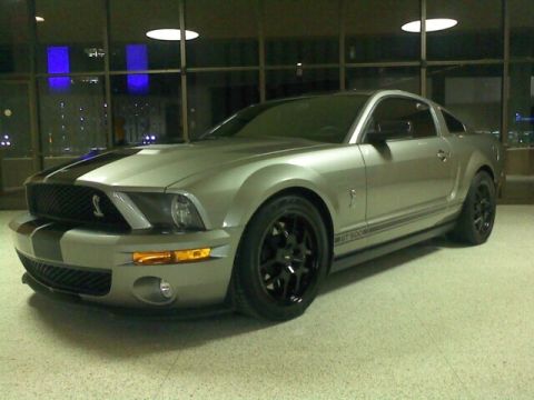 2000 Mercury Grand Marquis - Silver Ford Mustang Shelby GT500 parked indoors with black racing stripes and wheels.
