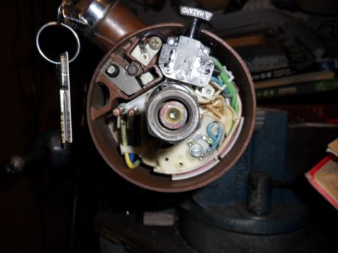 1973 Ford Ranchero - Close-up of a car's ignition switch assembly, held in a vise, with keys attached.