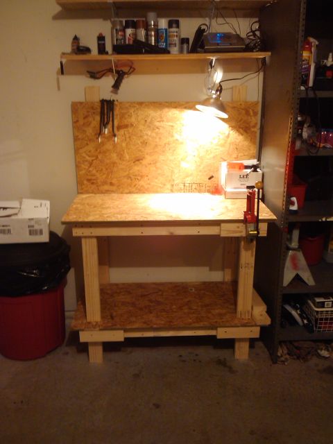 1989 Ford Bronco - Workbench setup with tools and supplies, including a red trash can and a box from LEE.