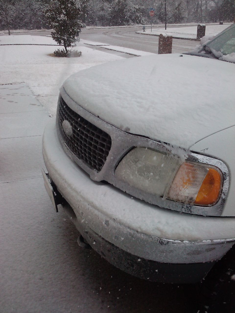2002 Ford Expedition front grille and headlight covered in snow