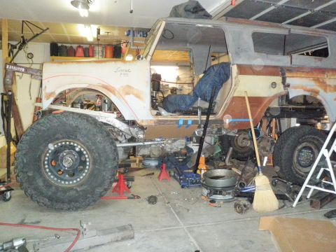 1961 International Scout 800 - A 1961 International Scout 800 is shown in a garage with extensive frame modifications and oversized tires, indicating a custom build or re…