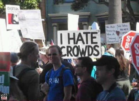 1988 Ford F-150 - A crowd of people are gathered outdoors, holding various signs with text.