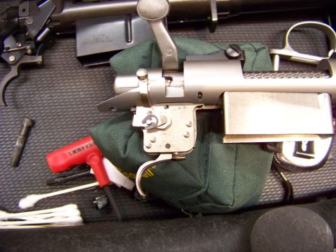 1995 Mercury Grand Marquis - Close-up of a rifle's bolt and trigger mechanism, alongside cleaning tools.