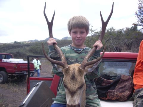 1991 Ford Bronco - A young hunter proudly displays his deer antlers in front of a red Toyota pickup truck.