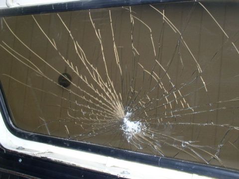1978 Ford Bronco - Badly cracked windshield with a starburst impact point low and right of center, radiating spider-web cracks across the entire tan-tinted gl…