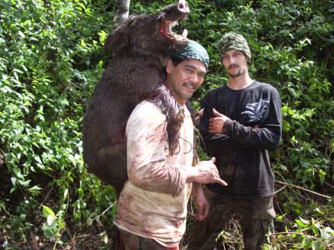 1991 Ford Bronco - Two men proudly display a large wild boar they have hunted, with a watermark visible in the lower right corner of the image.