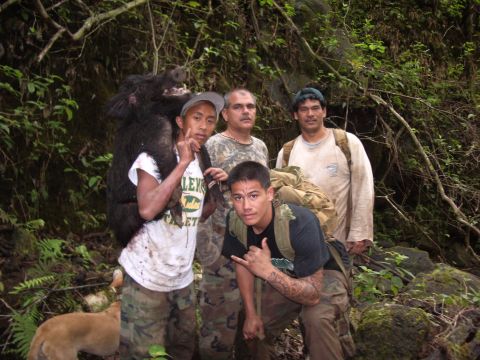1991 Ford Bronco - Hunters pose with their wild boar catch in a wooded area.