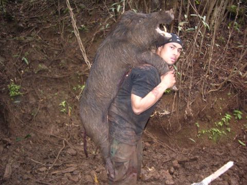 1991 Ford Bronco - Hunter carries a wild boar through a muddy forest after a successful hunt.